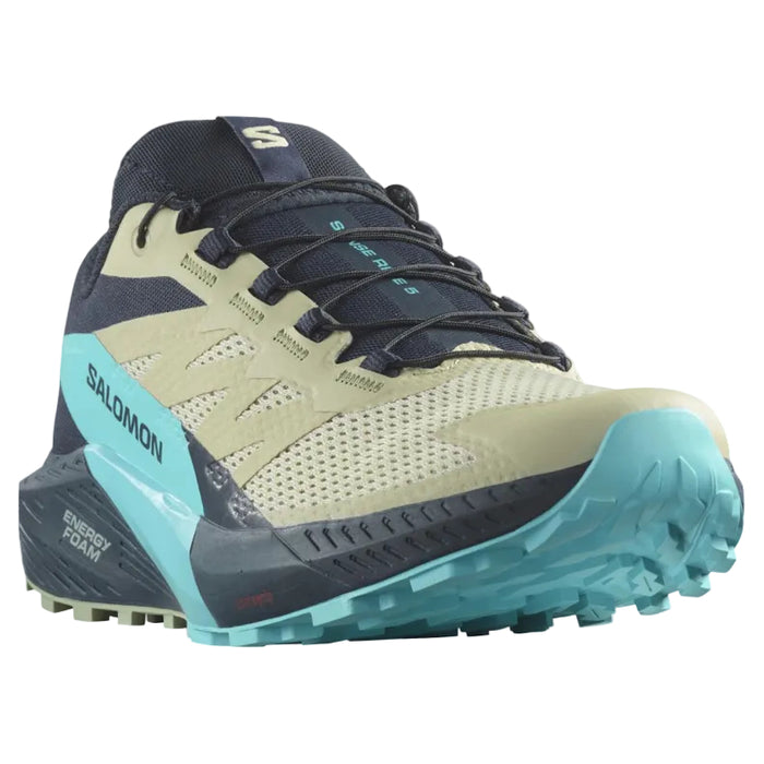 Salomon trail running shoe in beige, navy, and turquoise, shown from a side profile on a white background.
